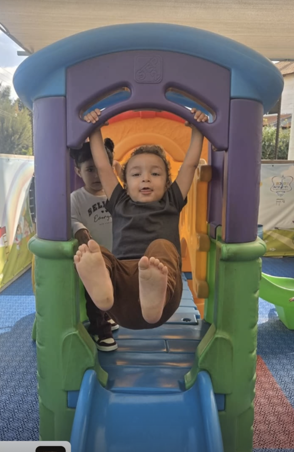 ילד משחק במתקן חצר צבעוני