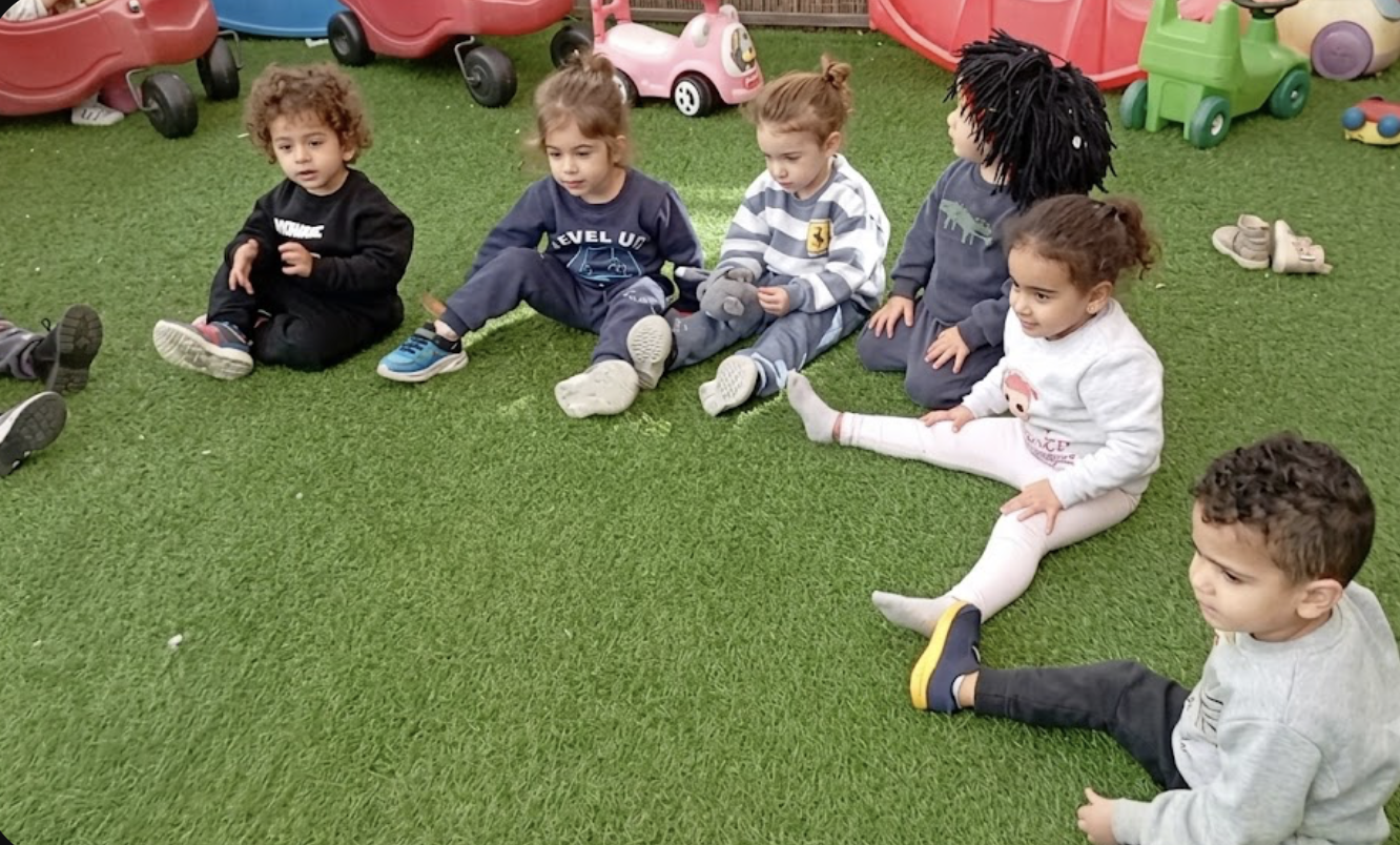 ילדים יושבים יחד במעגל בחצר